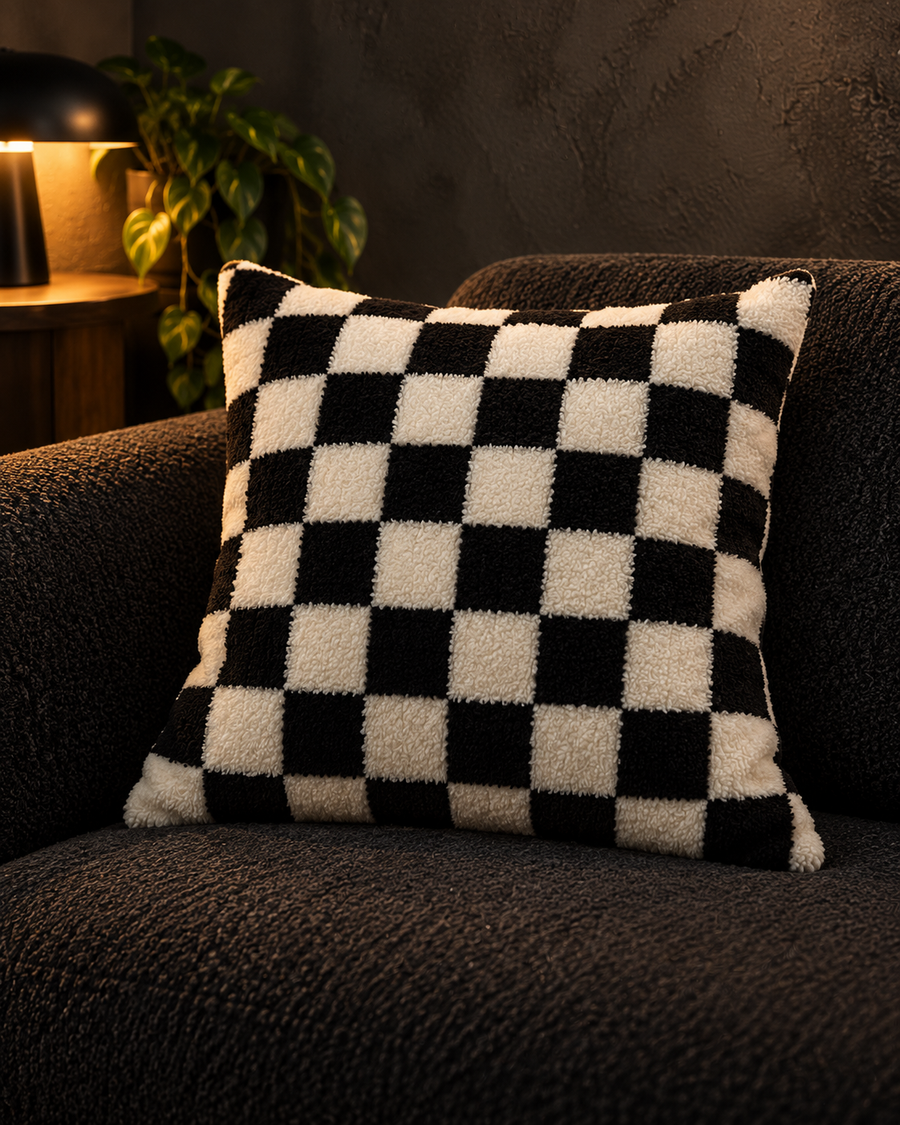 Black and ivory checkerboard cushion cover styled on a charcoal sofa